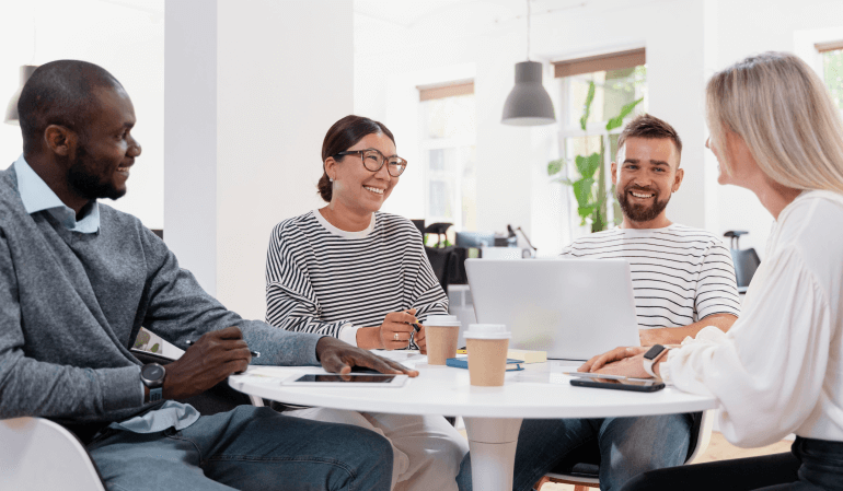 Equipe de corretores para lançamento imobiliário sentados à mesa conversando